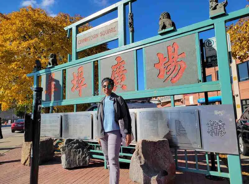 woman standing in front of Chinatown Square sign