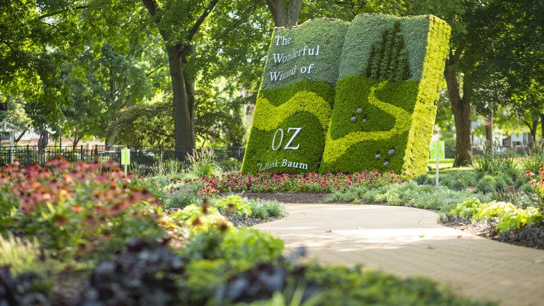 topiary shaped like a book in a park for the tale of Wizard of Oz